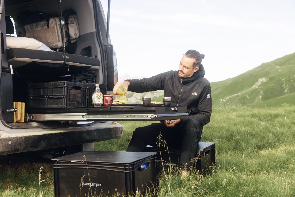 Ford Camper Van in der Heckansicht mit geöffneter Heckklappe und Heckauszügen als Sitzgruppe