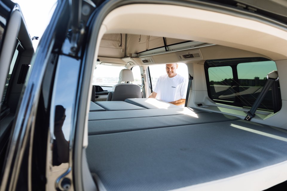 Kofferraum Ansicht vom VW Multivan auf Camping Bett