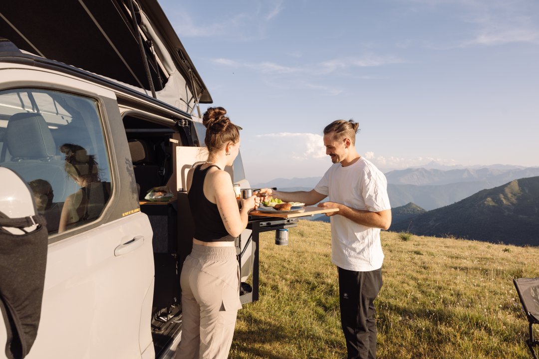 Personen am Offroad Camper von SpaceCamper auf einem Berg in den Westalpen 