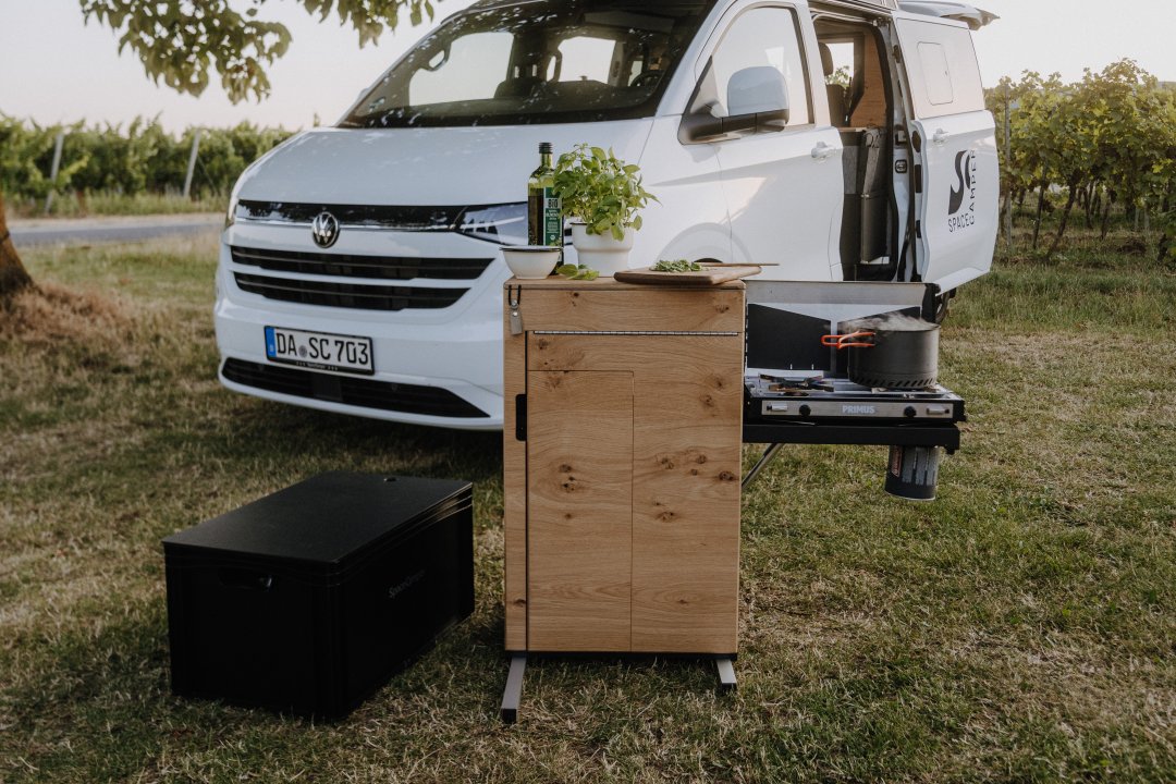 SpaceCamper Schwenkk&uuml;che im Classic+ Caravelle beim Kochen im Freien